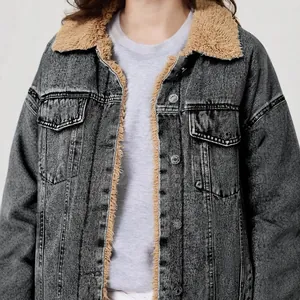 Detail einer gewaschenen grauen Jeansjacke mit warmem Sherpa-Fleecefutter und Metallknöpfen