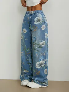 Détail de jean denim ample à jambes larges avec imprimés floraux blancs sur toute la surface.