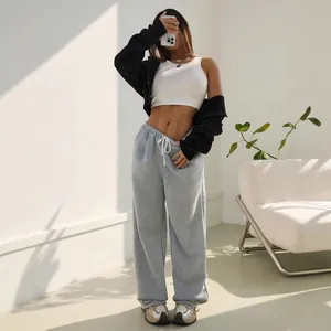 Pantalon de jogging gris ample et évasé avec un crop top blanc et un sweat à capuche noir.