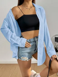 Détail d'une chemise bleu clair décontractée portée en couche légère avec un short