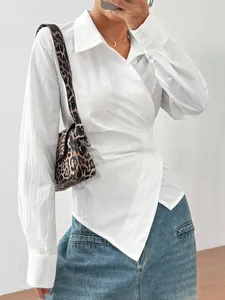 Dettaglio camicia bianca asimmetrica con design avvolgente in vita