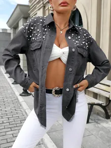Vue détaillée d'une veste en jean grise oversize avec perles blanches sur les épaules.