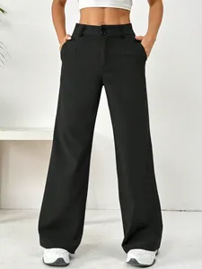 Vue de face d'un pantalon noir à taille haute montrant les détails de la double fermeture