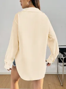 Vue arrière d'un chemisier décontracté beige à manches longues avec un ourlet arrondi