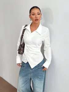 Dettaglio della camicia bianca asimmetrica con revers e design sciancrato