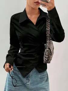 Dettaglio di un'elegante camicia nera a maniche lunghe con orlo irregolare e vita segnata
