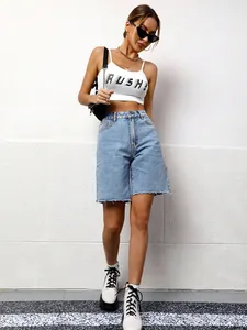 Full view of women's loose casual washed denim bermuda shorts with raw hem.