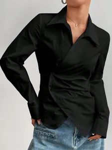 Dettaglio di una camicia nera a portafoglio con design irregolare che snellisce la vita.