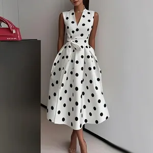 Elegant sleeveless white midi dress with large black polka dots and a waist tie for party.