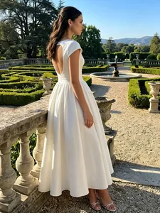 Elegant white short sleeve backless midi dress for women shown in a formal garden scene