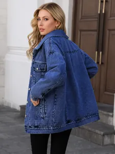 Vista laterale di un'elegante giacca di jeans blu oversize per donna all'aperto.