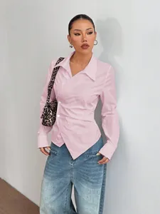 Dettaglio della camicia rosa asimmetrica a maniche lunghe con vita arricciata sul modello