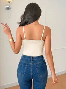 Back view of an elegant champagne satin camisole bodysuit with slim blue denim jeans.