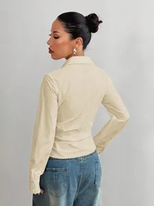 Vista posteriore dettagliata della camicia beige sciancrata a maniche lunghe con revers donna