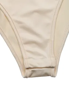 Macro detail of the beige bodysuit crotch with adjustable snap closures.