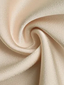 Macro detail of elegant champagne gold satin fabric with luxurious silky sheen and texture
