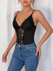 Detailed shot of a black lace patchwork V-neck bodysuit paired with high-waisted jeans