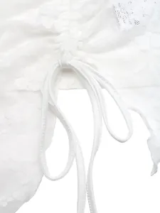 Close-up detail of white floral lace camisole showing adjustable drawstring tie texture