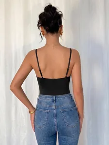 Back view detail of a sleek black backless camisole bodysuit styled with blue denim jeans