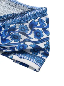 Detailed macro shot of blue floral ethnic print and elastic smocking on white fabric