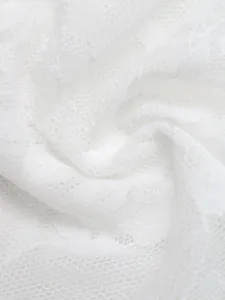 Macro detail of delicate white floral lace fabric for see-through summer vest