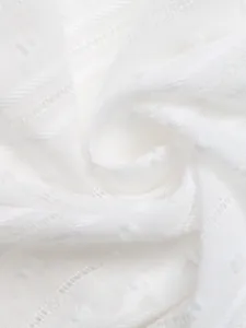 Close-up detail van witte jacquard stof met kant en delicate stipmotieven