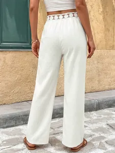 Vista posteriore dei pantaloni bianchi a gamba larga con pizzo traforato in vita