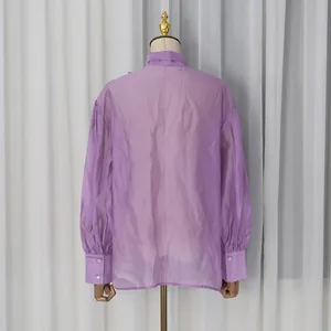 Vista trasera de una elegante blusa lavanda transparente con mangas de linterna.
