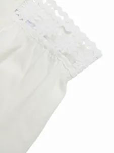 Dettaglio ravvicinato di pantaloni bianchi con bordo decorativo in pizzo floreale