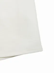 Dettaglio ravvicinato dei pantaloni bianchi con texture in lino e cuciture sull'orlo