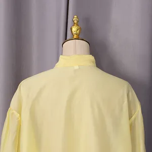 Detalle que muestra la textura de la tela de una camisa de cuello alto amarillo claro