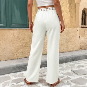 Pantaloni bianchi larghi da donna con delicati dettagli in pizzo traforato in vita