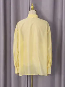 Elegante blusa amarilla de manga larga para mujer, vista posterior en un maniquí