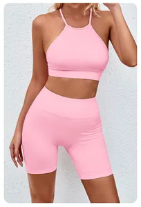 Close-up of pink seamless yoga set showing high-waisted shorts and halter bra detail