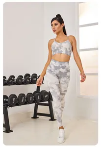 Modèle portant un ensemble de yoga sans couture tie-dye gris et blanc dans un studio de fitness