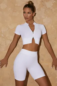 Λεπτομέρεια του λευκού ribbed yoga σετ χωρίς ραφές με crop top με φερμουάρ και σορτς.
