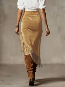 Back view of a vintage western style camel suede skirt with fringe and asymmetric hem.