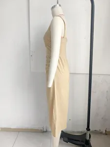 Zijaanzicht detail van een elegante kaki midi-jurk met brede bandjes op een witte etalagepop
