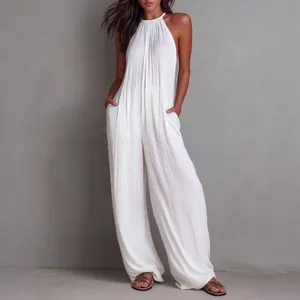 Detail of white pleated halter jumpsuit showing fabric texture and wide-leg fit
