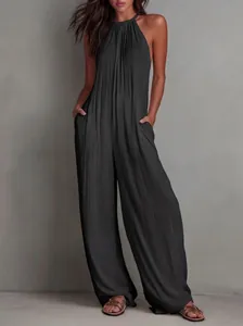 Detailed view of a chic black pleated halter-neck wide-leg jumpsuit on a model for vacation
