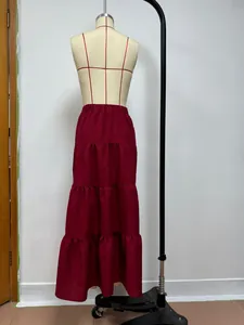 Dettaglio di una gonna maxi a balze bordeaux con vita alta elastica su un manichino