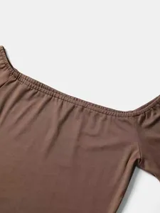 Primo piano della scollatura elasticizzata di questo elegante top marrone con spalle scoperte