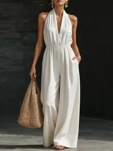 Elegante mono blanco con cuello halter y pernera ancha para un look de verano sofisticado
