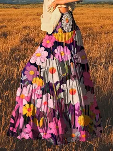 Bohemian maxi-rok met levendige olieverf bloemenprints in een gouden veldomgeving.