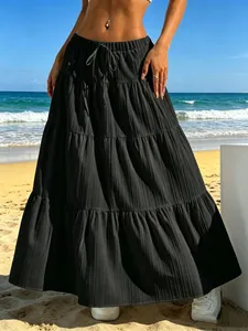 Vista dettagliata di una gonna lunga nera a balze con coulisse in una spiaggia soleggiata