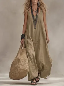Close-up of Bohemian khaki maxi dress styled with ethnic necklaces and a woven straw bag