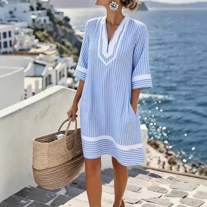 Bohemian light blue striped V-neck beach dress shown in a seaside vacation setting