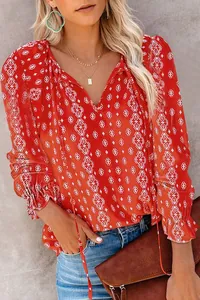 Close-up of red bohemian blouse featuring white geometric diamond patterns and V-neckline