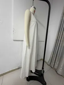 Side view detail of a white sleeveless Bohemian maxi dress on a garment mannequin.