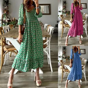 Dettaglio vestito lungo boho a fiori con corpino a punto smock verde rosa blu